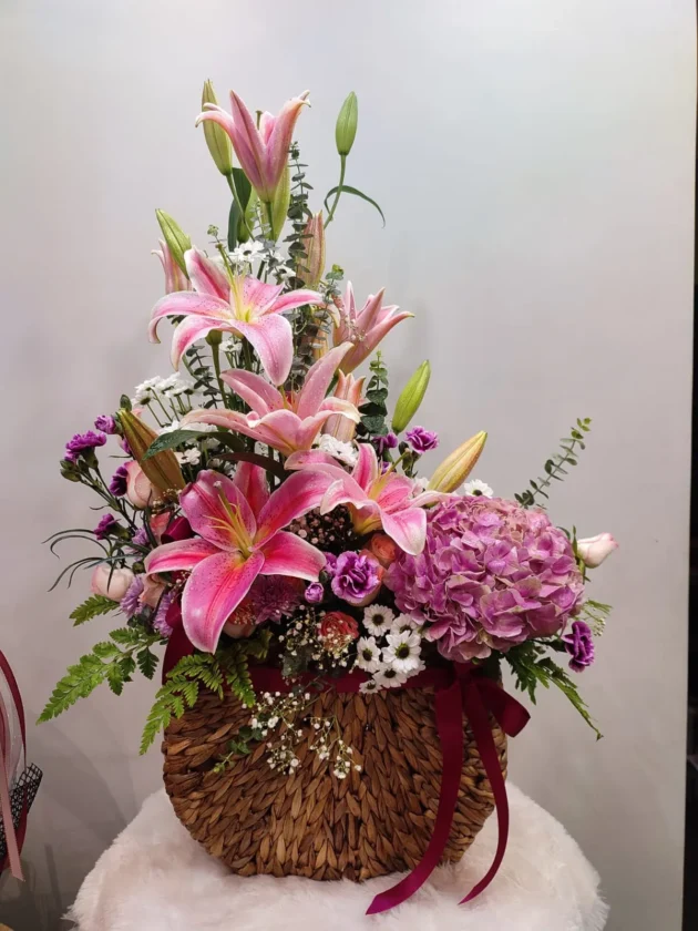Hydrangea lilies arrangement in water hyacinth basket