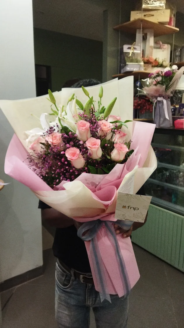 lilies and pink shaded roses with colored gypso hand tied bunch